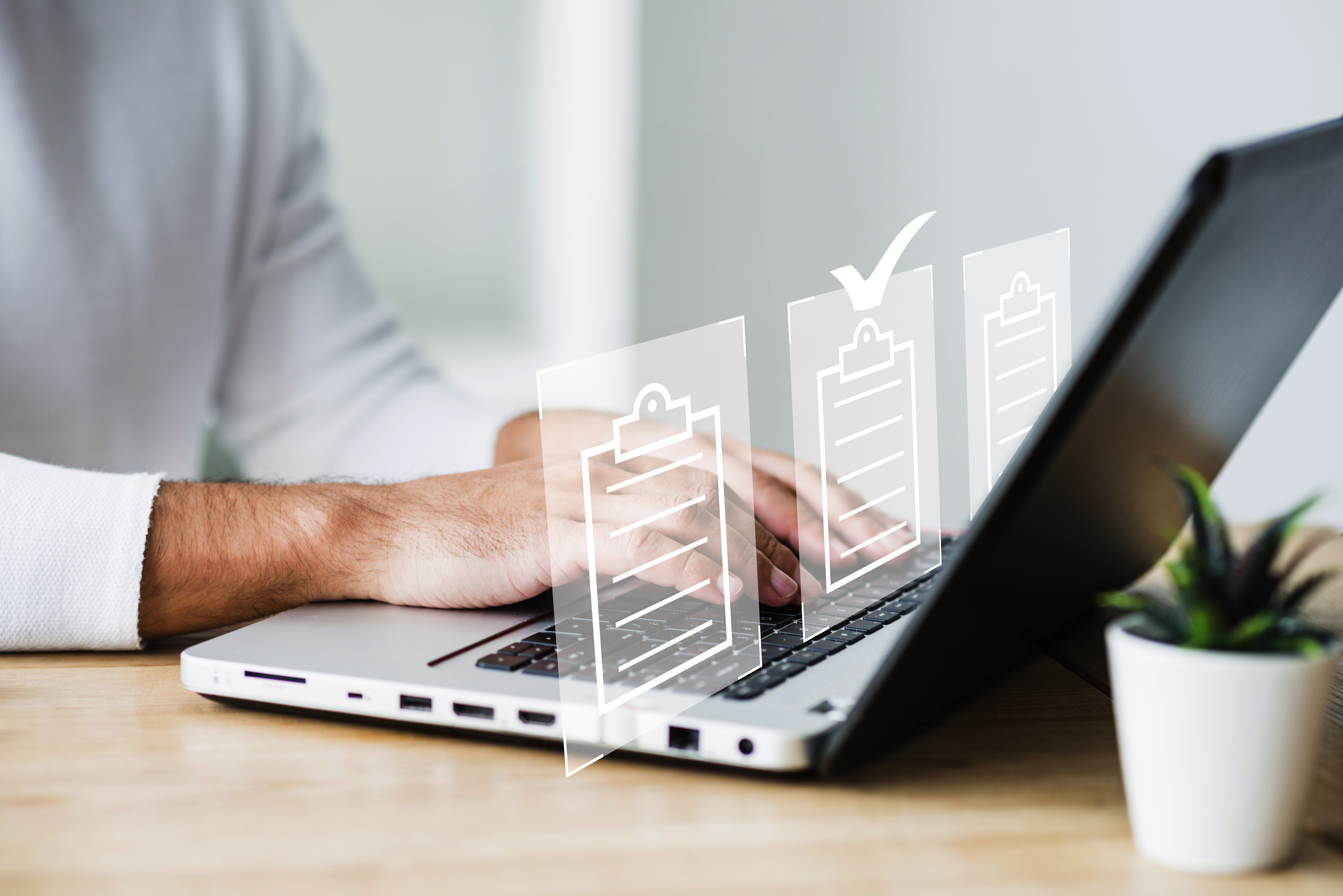 Pessoa digitando em computador e ícones de documentos 